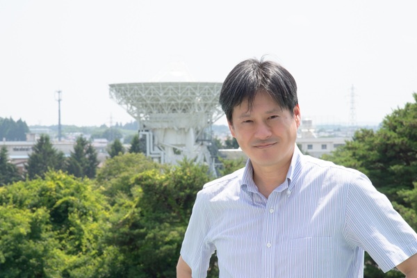 本間希樹 教授と水沢観測局VERA20mアンテナ（Credit: 国立天文台）